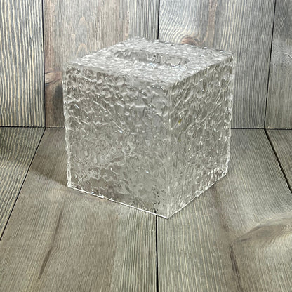 Clear acrylic tissue holder with ripple texture, showcasing modern design on wooden surface, perfect for bathroom decor.