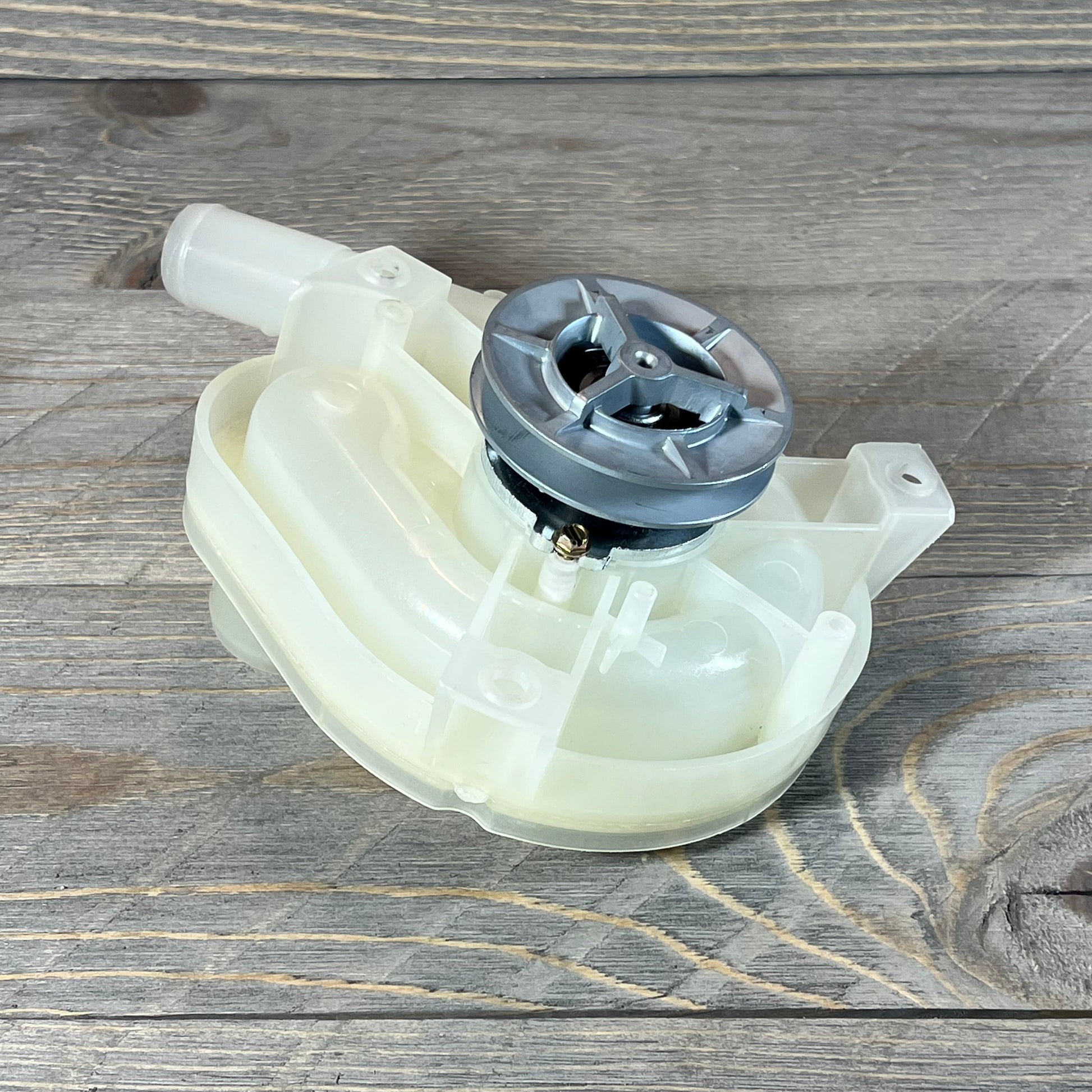 Top load washer drain pump and pulley replacement on a wooden surface, showcasing durable build and design.