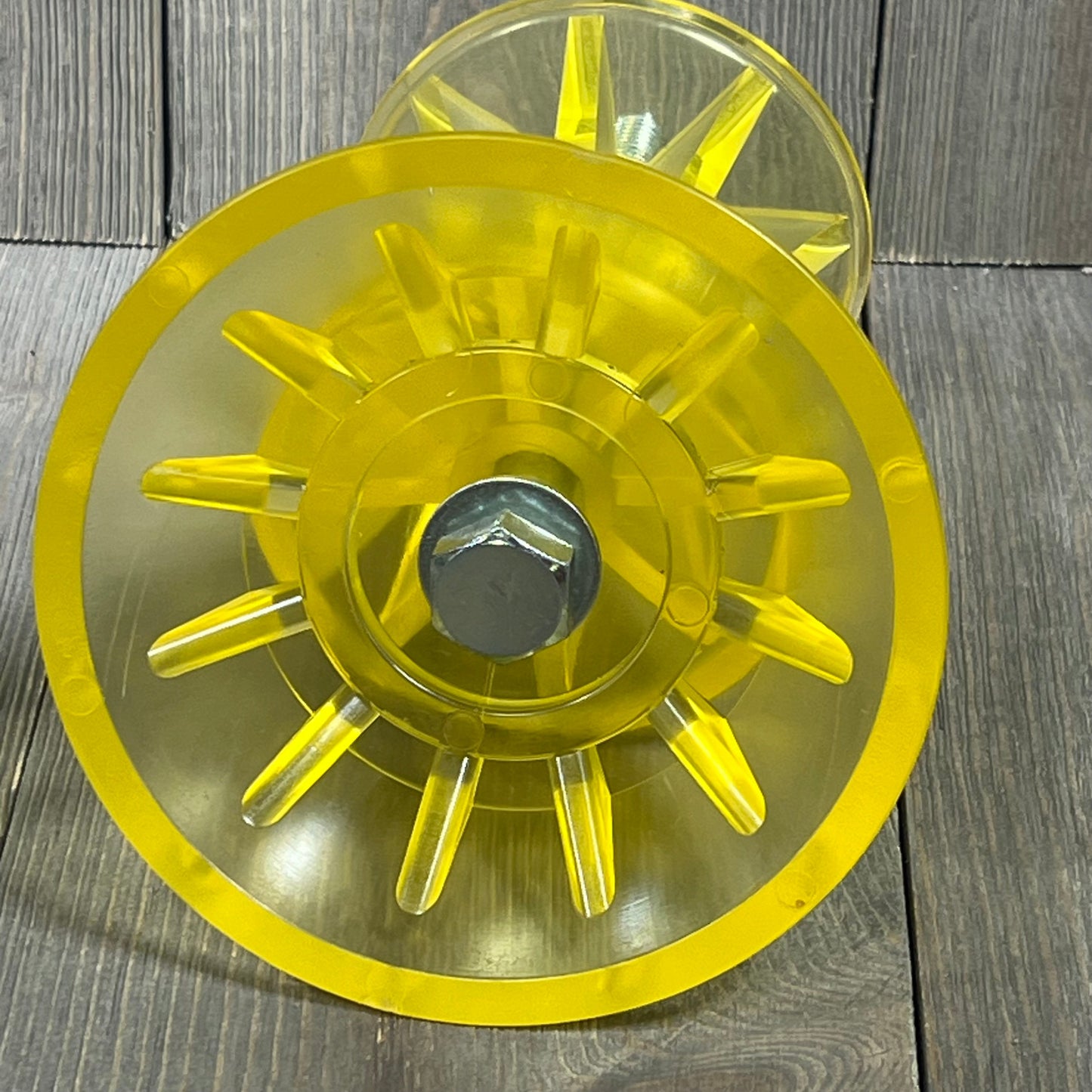 Yellow SeaSense Super Polymer Bow Roller, 4-inch, displaying durable polymer construction against a wooden background.