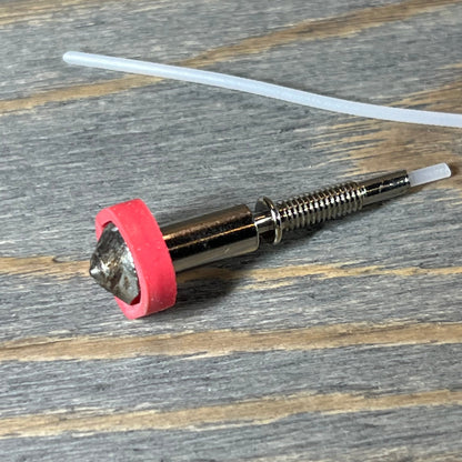 Tungsten carbide nozzle for E3D Revo HotEnd on wooden surface, showcasing high thermal conductivity and precision.