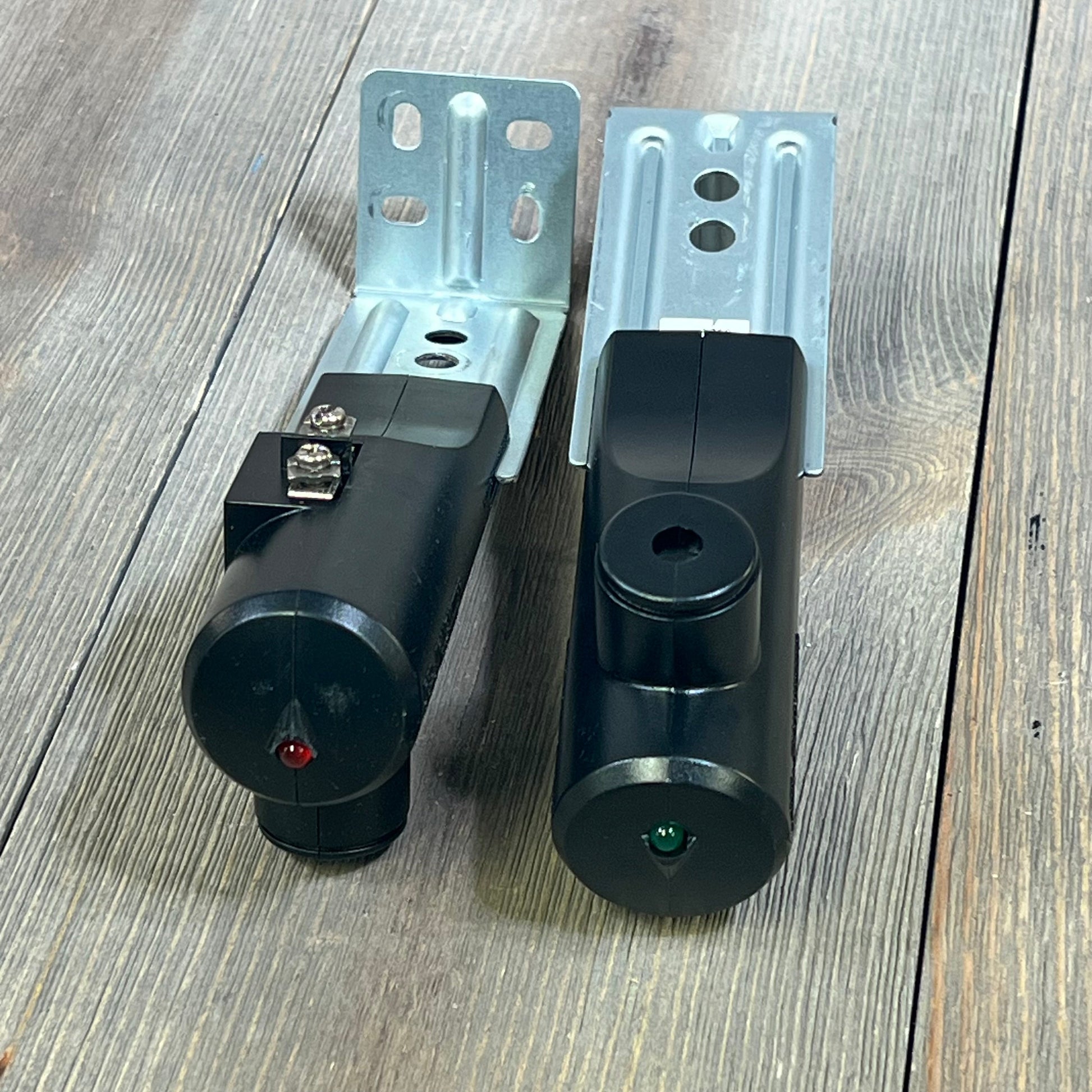 Genie Safe-T-Beam Replacement Kit featuring black sender and receiver units on a wooden surface.
