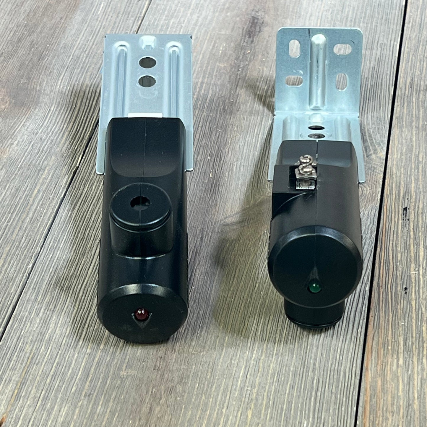 Black Genie Safe-T-Beam replacement kit with sender and receiver on wood surface, featuring durable metal brackets.
