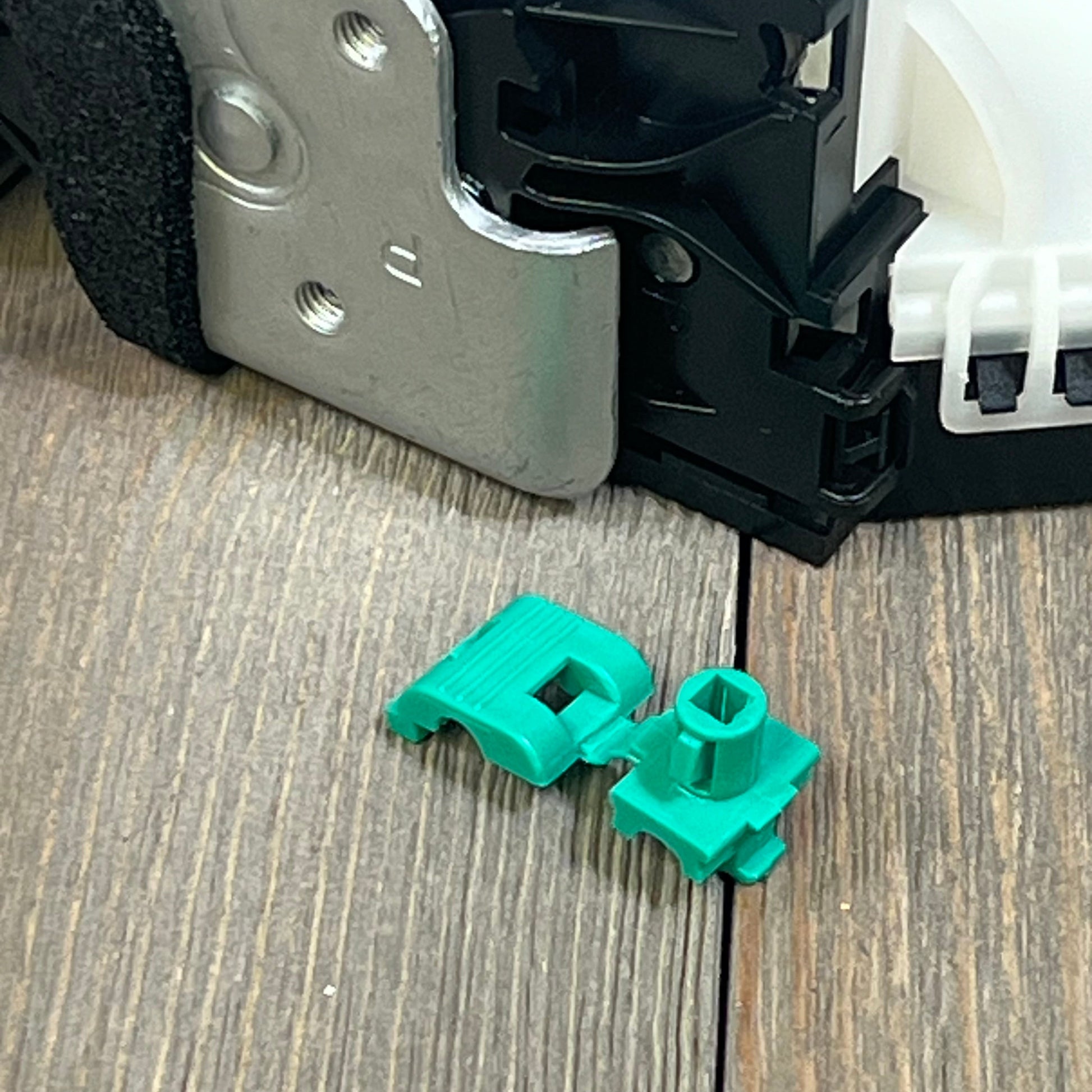 Close-up of 1047213943-ApplianPar rear passenger side door lock actuator latch for Ford F150, showing metal and green components.