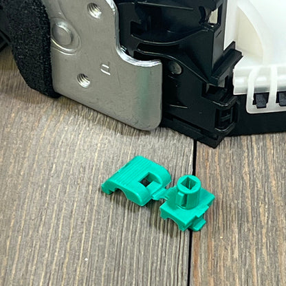 Close-up of 1047213943-ApplianPar rear passenger side door lock actuator latch for Ford F150, showing metal and green components.