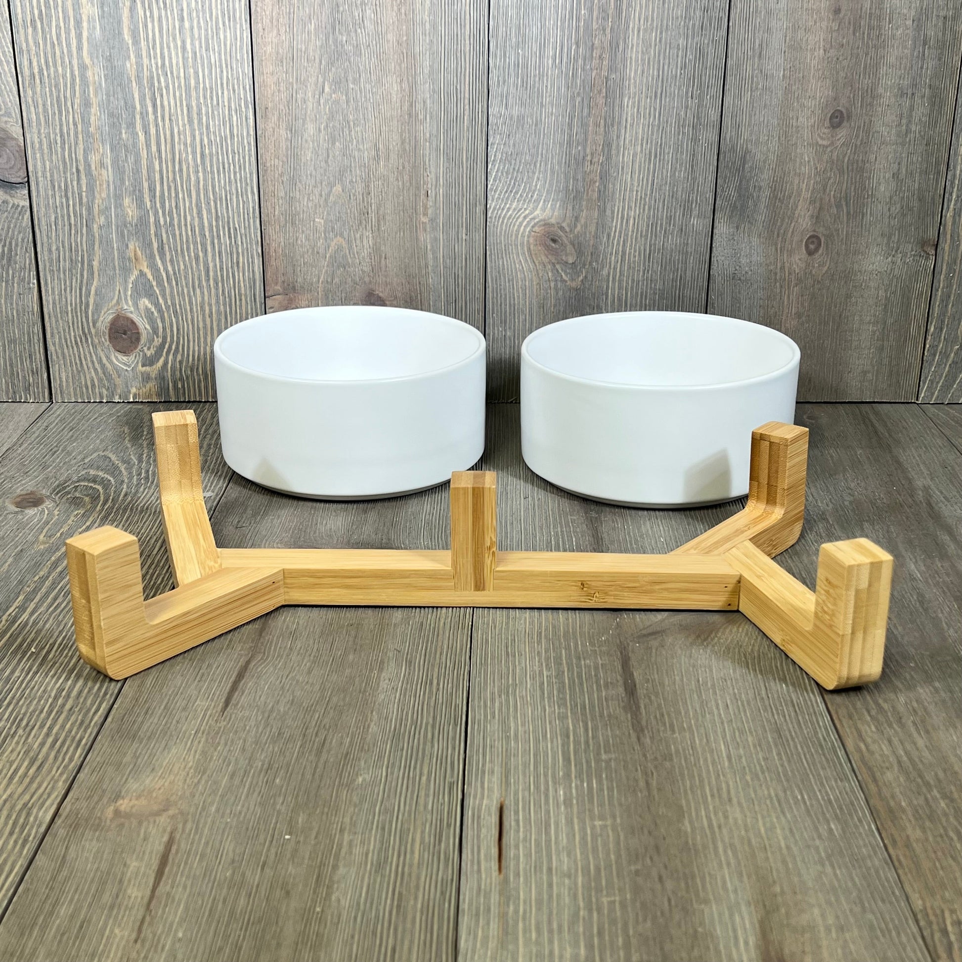 Ceramic dog and cat bowls with a sleek wood stand, perfect for medium pets. Non-slip design with a matte glaze finish.