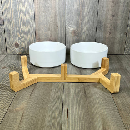 Ceramic dog and cat bowls with a sleek wood stand, perfect for medium pets. Non-slip design with a matte glaze finish.