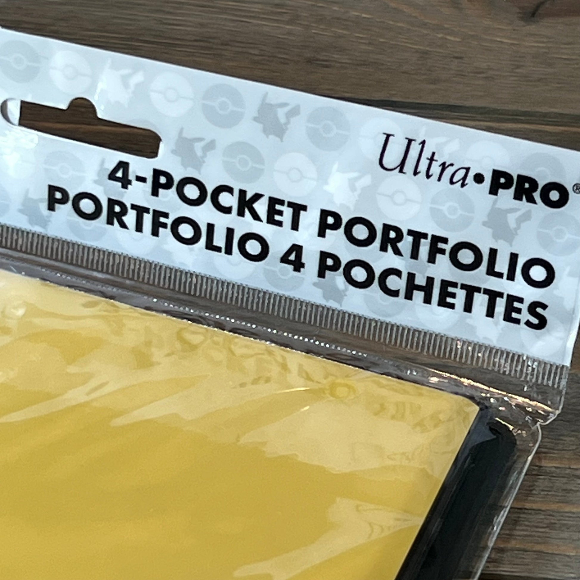 Ultra Pro Pikachu 4-pocket portfolio packaging with Pokemon-themed design on a wooden table.