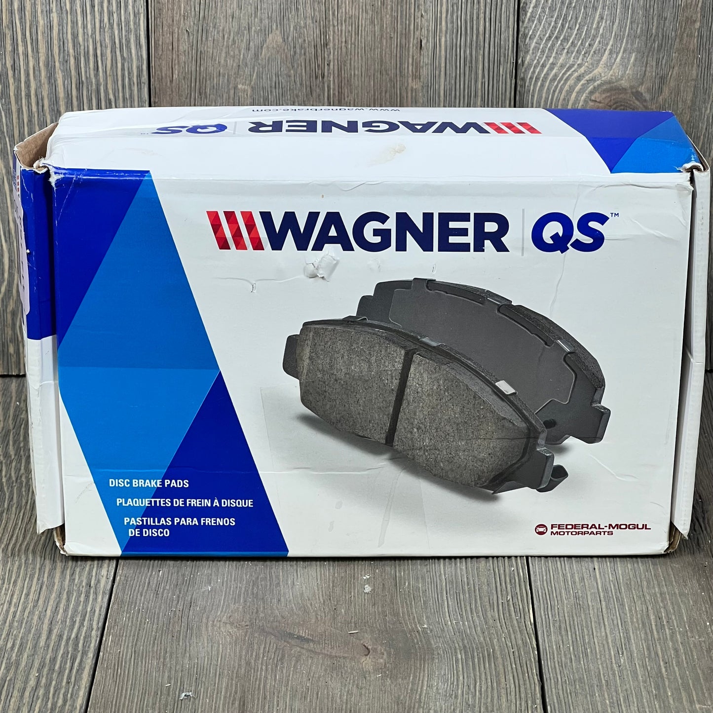 Wagner QuickStop ZD711 Rear Disc Brake Pad Set packaging for 2003 Ford F-150 on wooden surface.