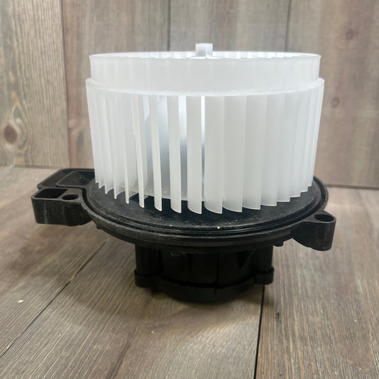 HVAC plastic heater blower motor with ABS fan cage for Ford Fusion 2006-2009, shown on a wooden surface.