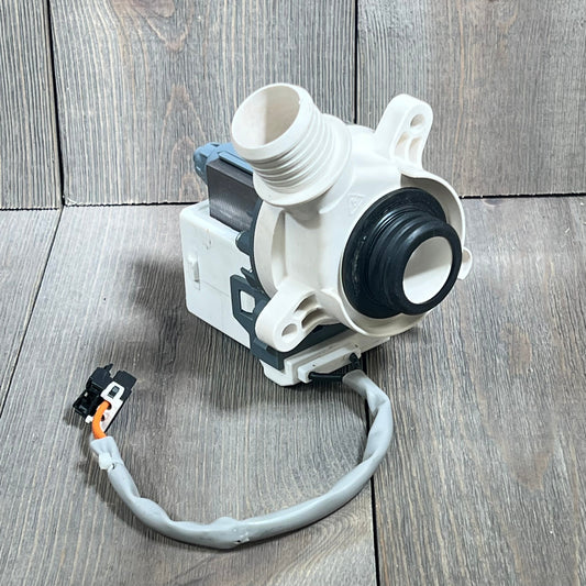 Hotpoint GE Washer Drain Pump Motor WH23X28418, showcasing connections and robust build on a wood surface.