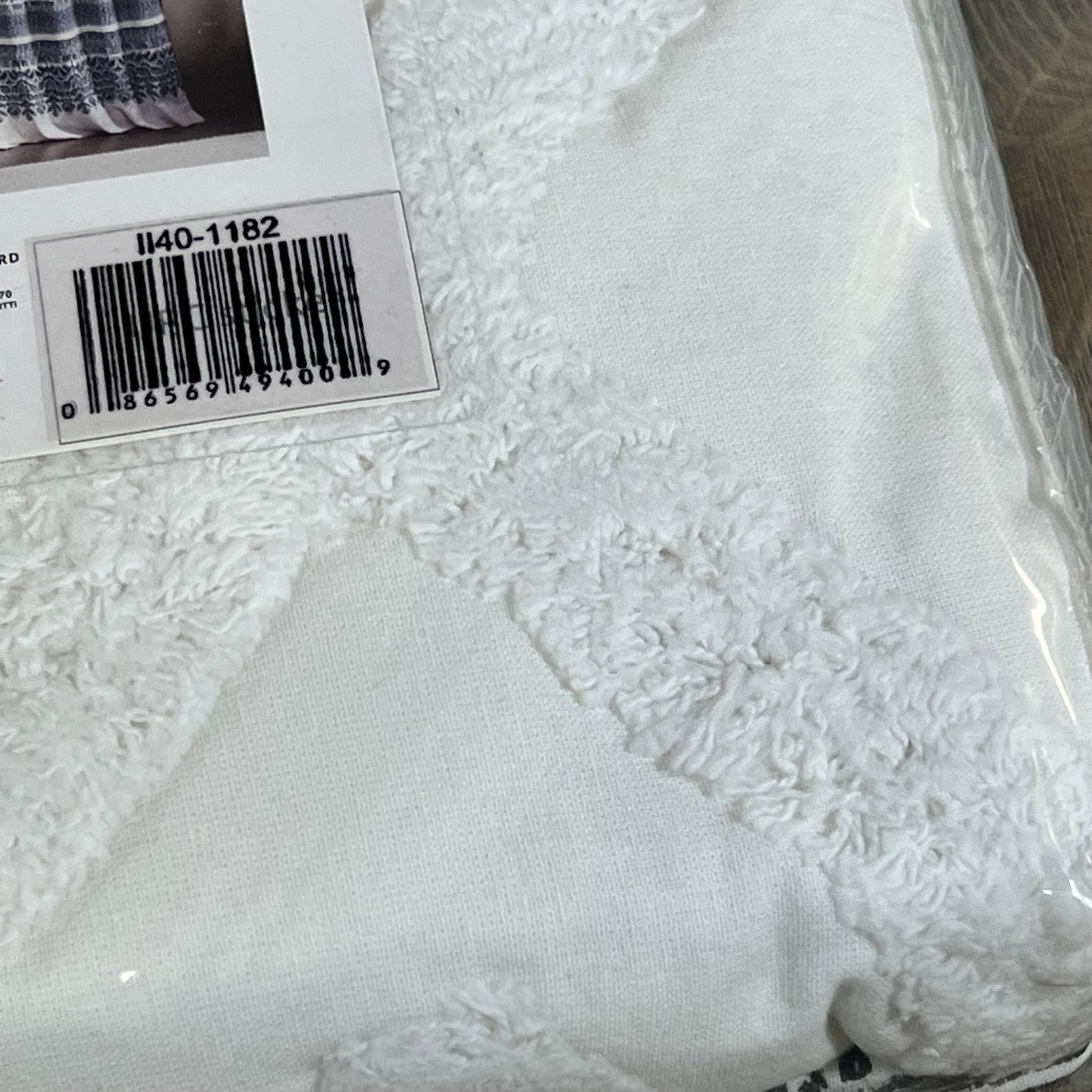 Navy and white tufted chenille curtain fabric with a boho design, showcasing the texture and pattern detail.