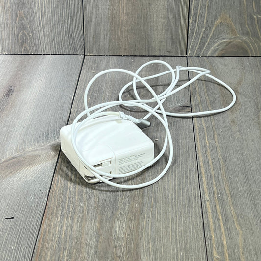 White 45W Mag2 T-Tip MacBook Air charger coiled neatly on a wooden surface, compatible with 11" and 13" models post-2012.