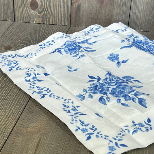 Blue floral linen table runner on wood table, showcasing Jolie Fleur print, perfect for summer decor, handcrafted and washable.