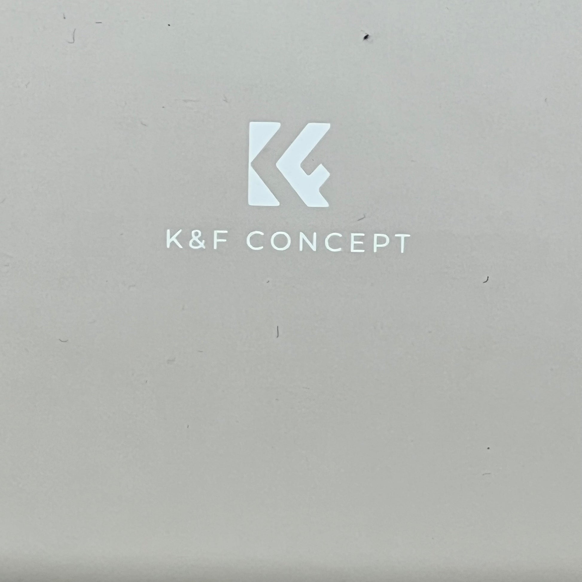 Beige K&F Concept camera case logo, showcasing brand identity on smooth surface, ideal for compact, stylish protection.