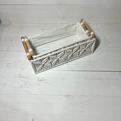 Handwoven macrame storage basket in ivory white with wooden handles, ideal for bathroom or bedroom decor. Bohemian style organizer.