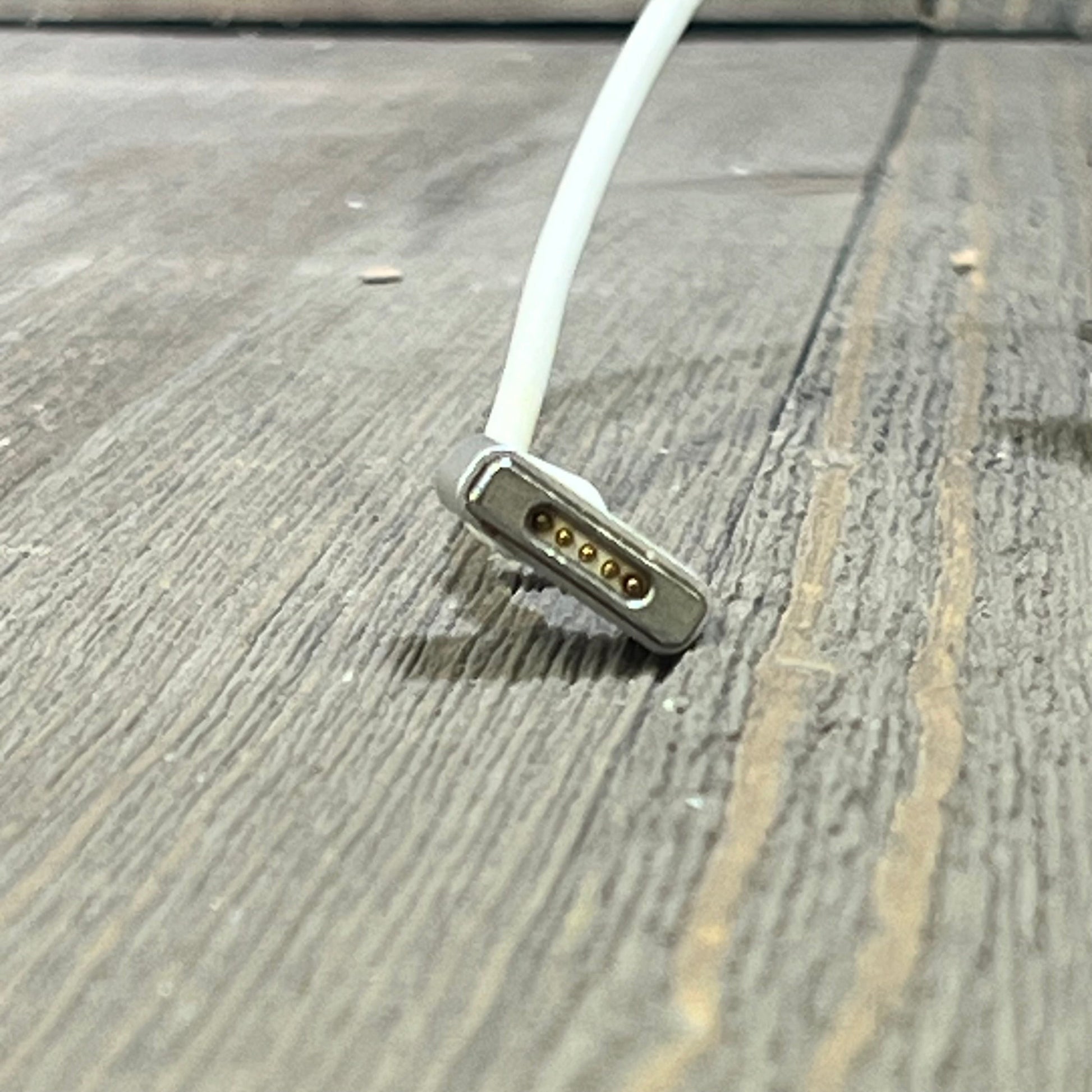 Close-up of the MagSafe T-Tip connector for the 45W MacBook Air charger, highlighting its magnetic pins.