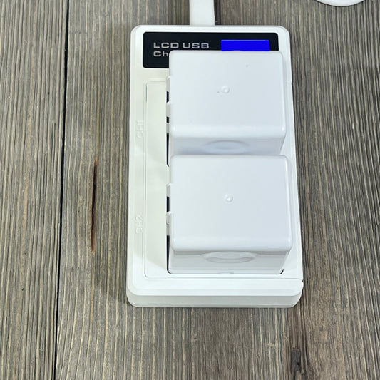 Dual LCD charger with two A-1 VMA4400 batteries for Arlo Pro cameras on a wooden surface.