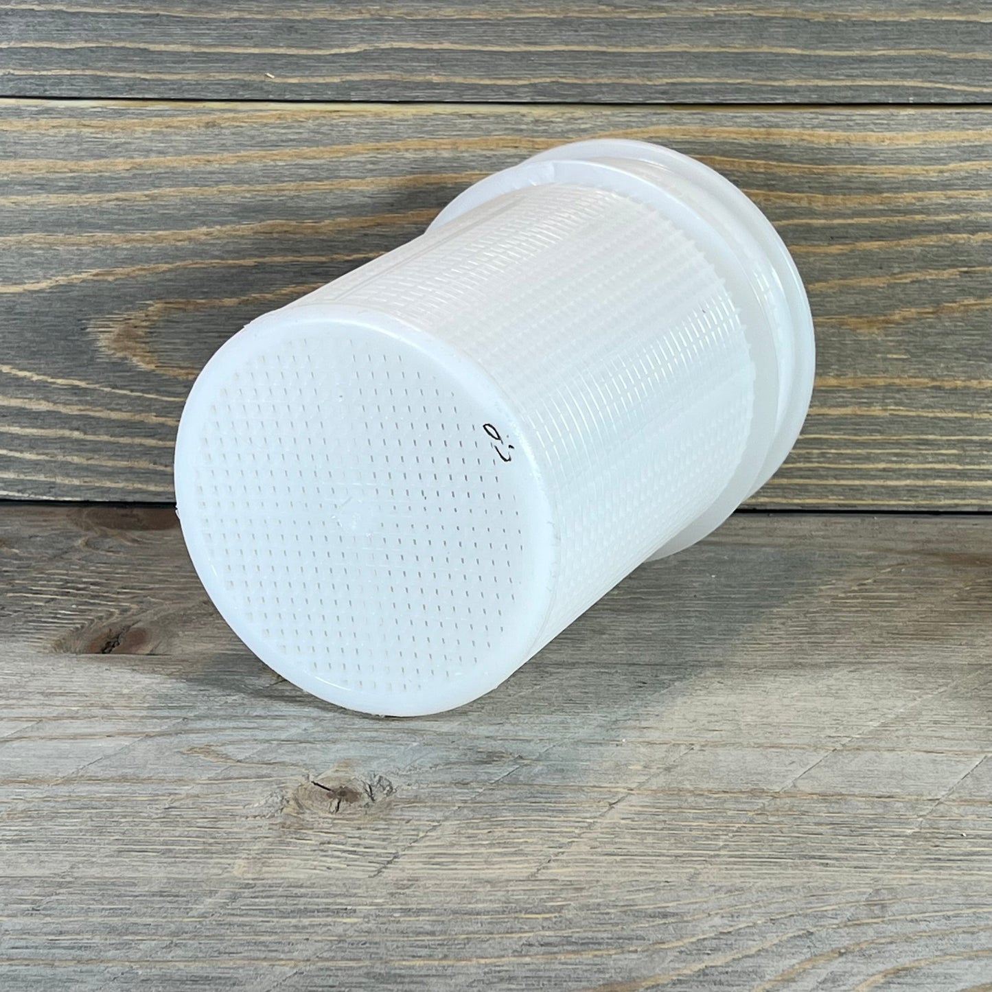 White Pentair 16920-0017 strainer basket on wooden surface, showcasing its durable plastic mesh design.