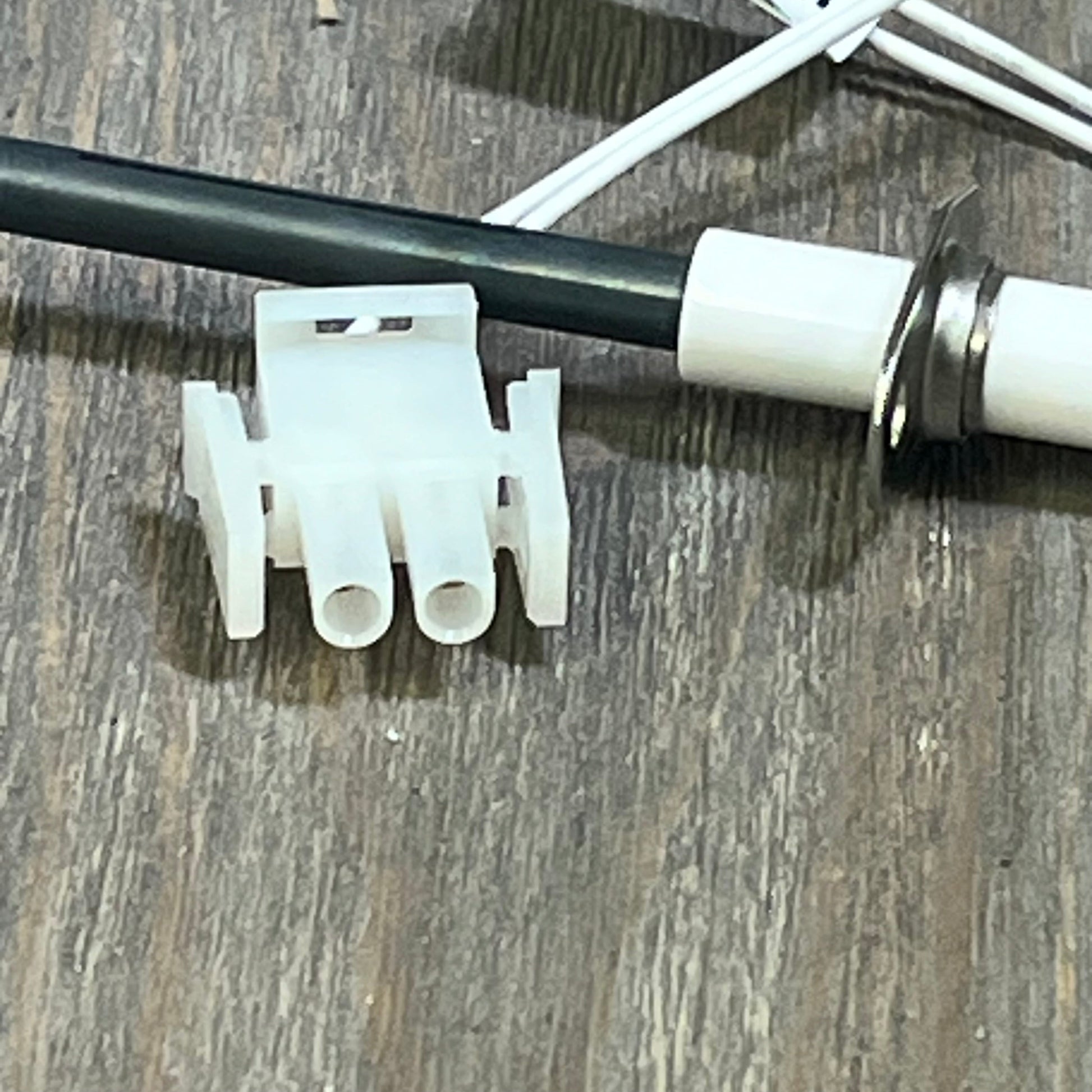 Silicon Nitride Ignitor Kit for Hayward H-Series Heaters, featuring cylindrical igniter head and connector on wood surface.