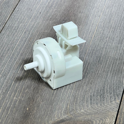 Whirlpool washer pressure switch W11316246, showing detailed design on wooden surface.