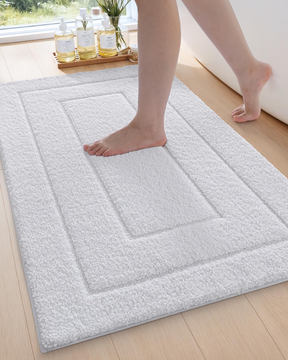 Soft white DEXI bathroom rug with non-slip rubber backing, perfect for shower floors. Extra large and quick-dry microfiber mat.