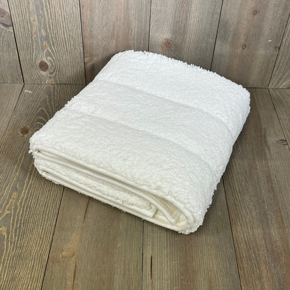 Folded DEXI bathroom rug 43x24, showcasing its soft, absorbent microfiber and non-slip rubber backing on a wooden floor.