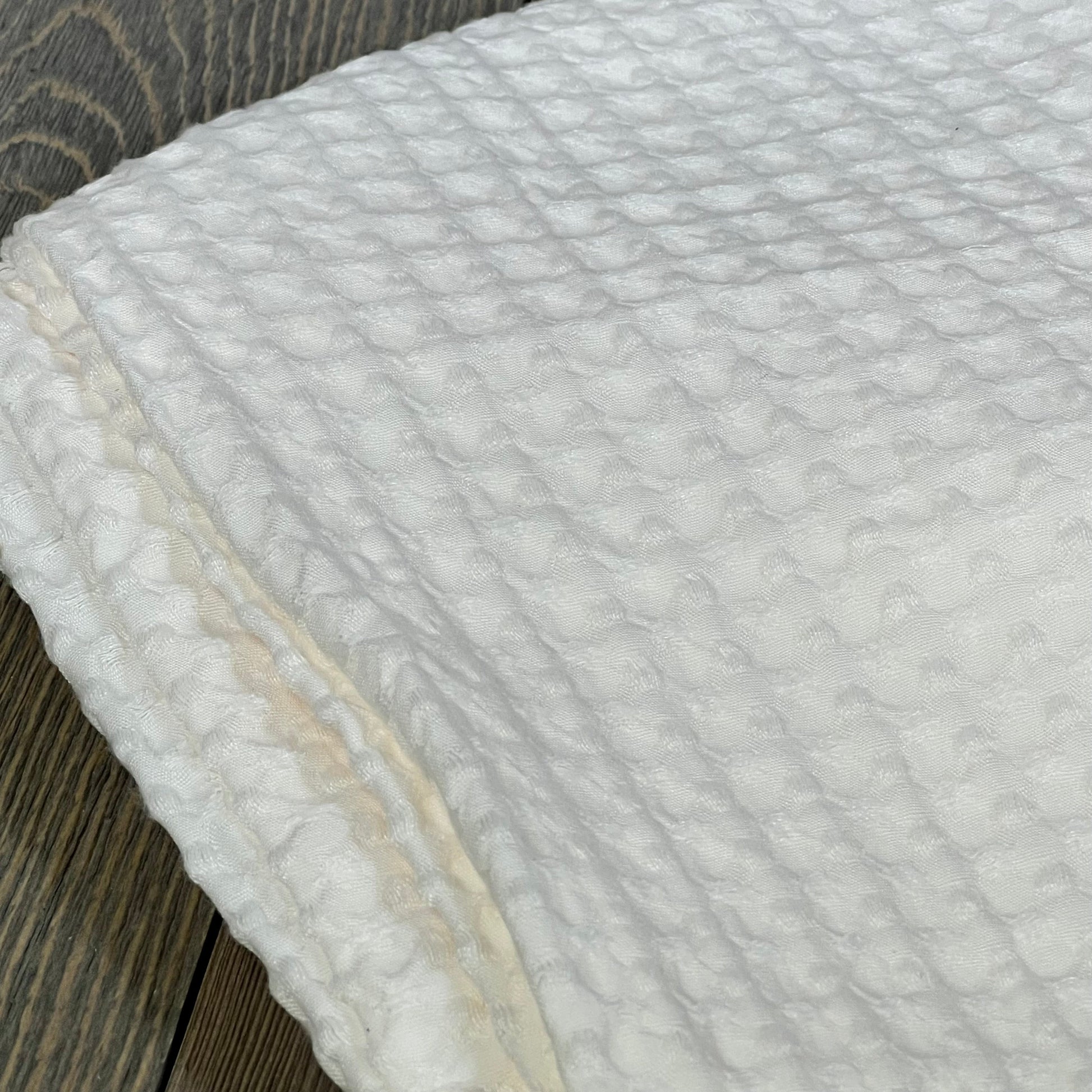 Coconut white PHF waffle weave pillow sham showcasing its soft, breathable texture on a wooden surface.