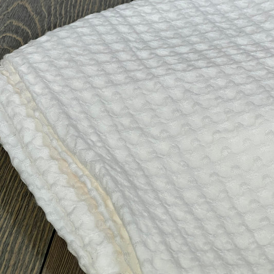 Coconut white PHF waffle weave pillow sham showcasing its soft, breathable texture on a wooden surface.