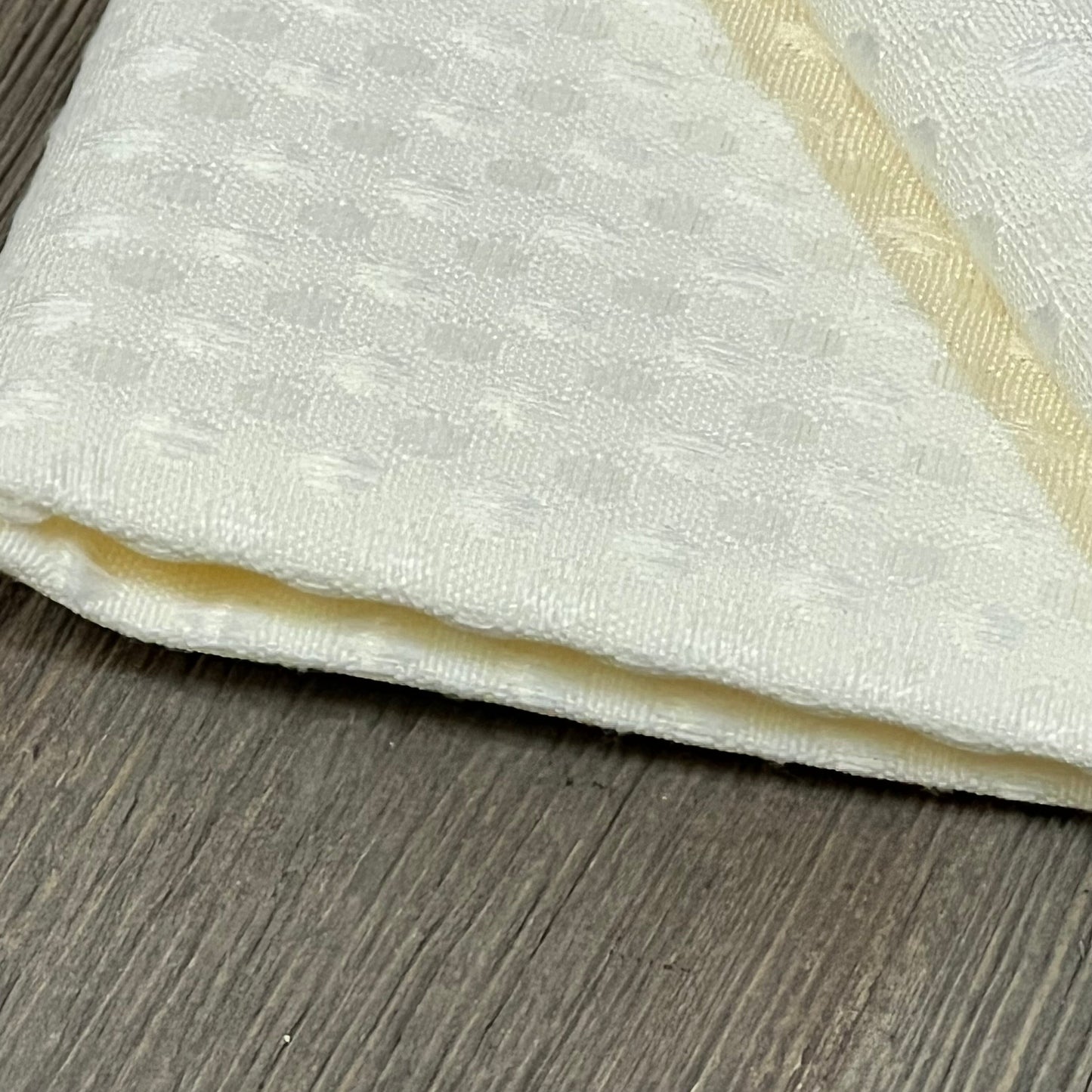 White waffle textured outdoor pillow cover on wooden surface, showcasing detailed polyester fabric design.