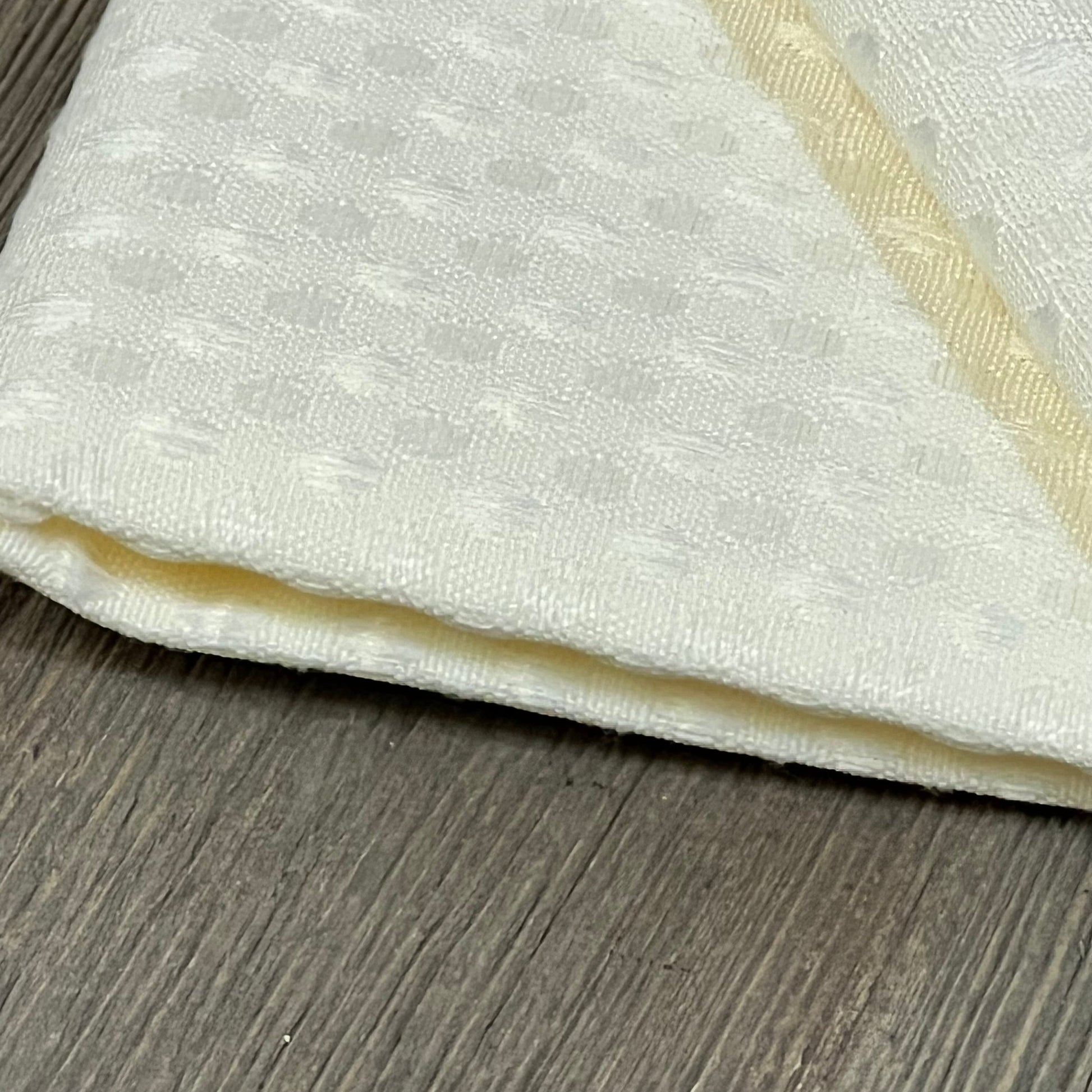 White waffle textured outdoor pillow cover on wooden surface, showcasing detailed polyester fabric design.