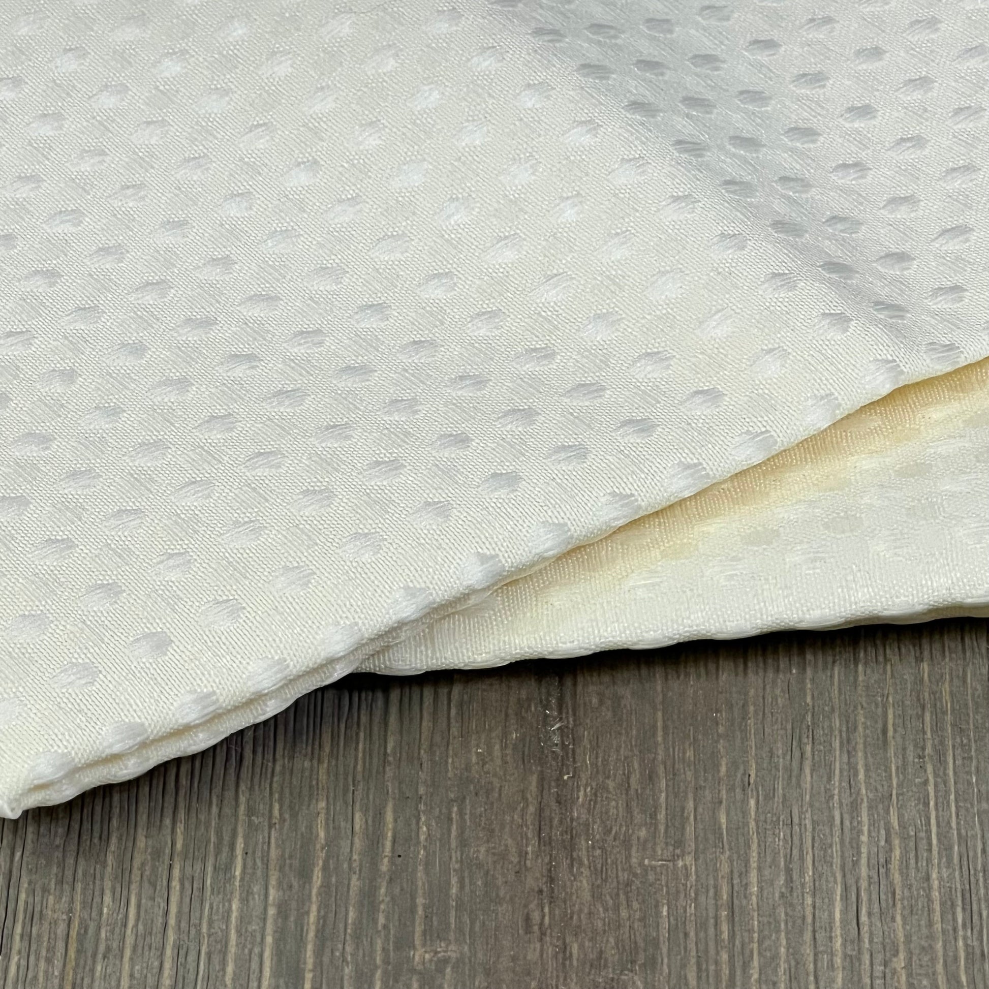 White waffle-textured outdoor pillow covers on wooden surface, ideal for patio furniture and garden decor. Waterproof and durable.