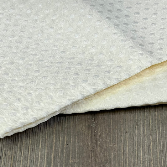 White waffle-textured outdoor pillow covers on wooden surface, ideal for patio furniture and garden decor. Waterproof and durable.