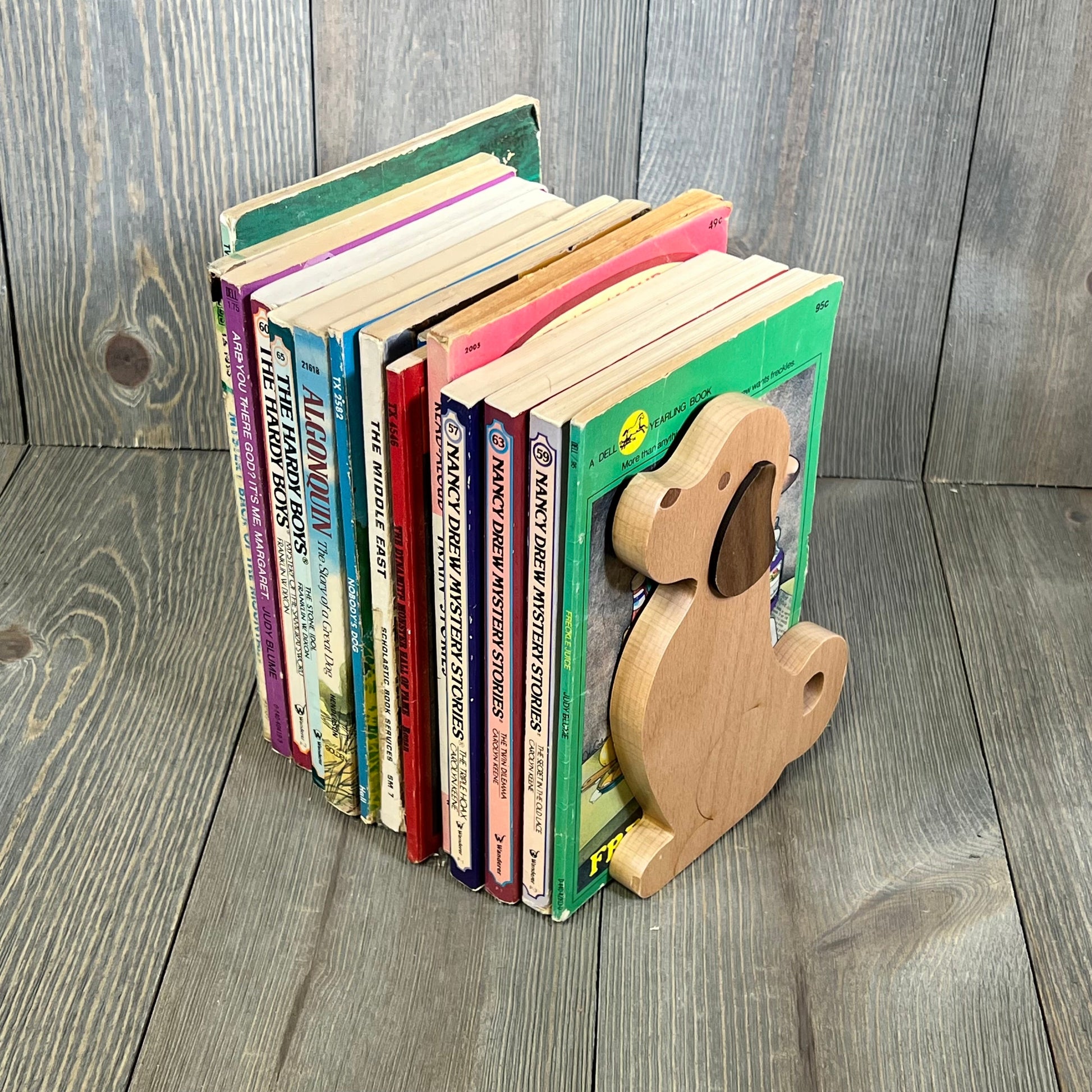 Decorative wooden puppy dog bookends holding children's books on a wooden shelf, perfect for kids' rooms and offices.
