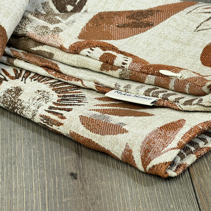 Sunflower pattern pillow covers in brown and cream, folded neatly, showcasing texture and Mika Home label.